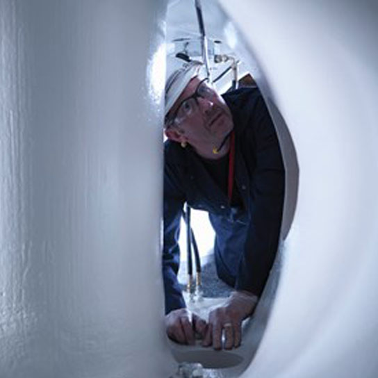 Engineer inspecting white pipe